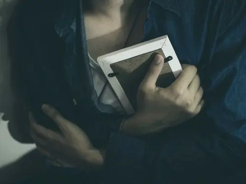 Überwindung von Untreue - Frau umklammert ein Foto