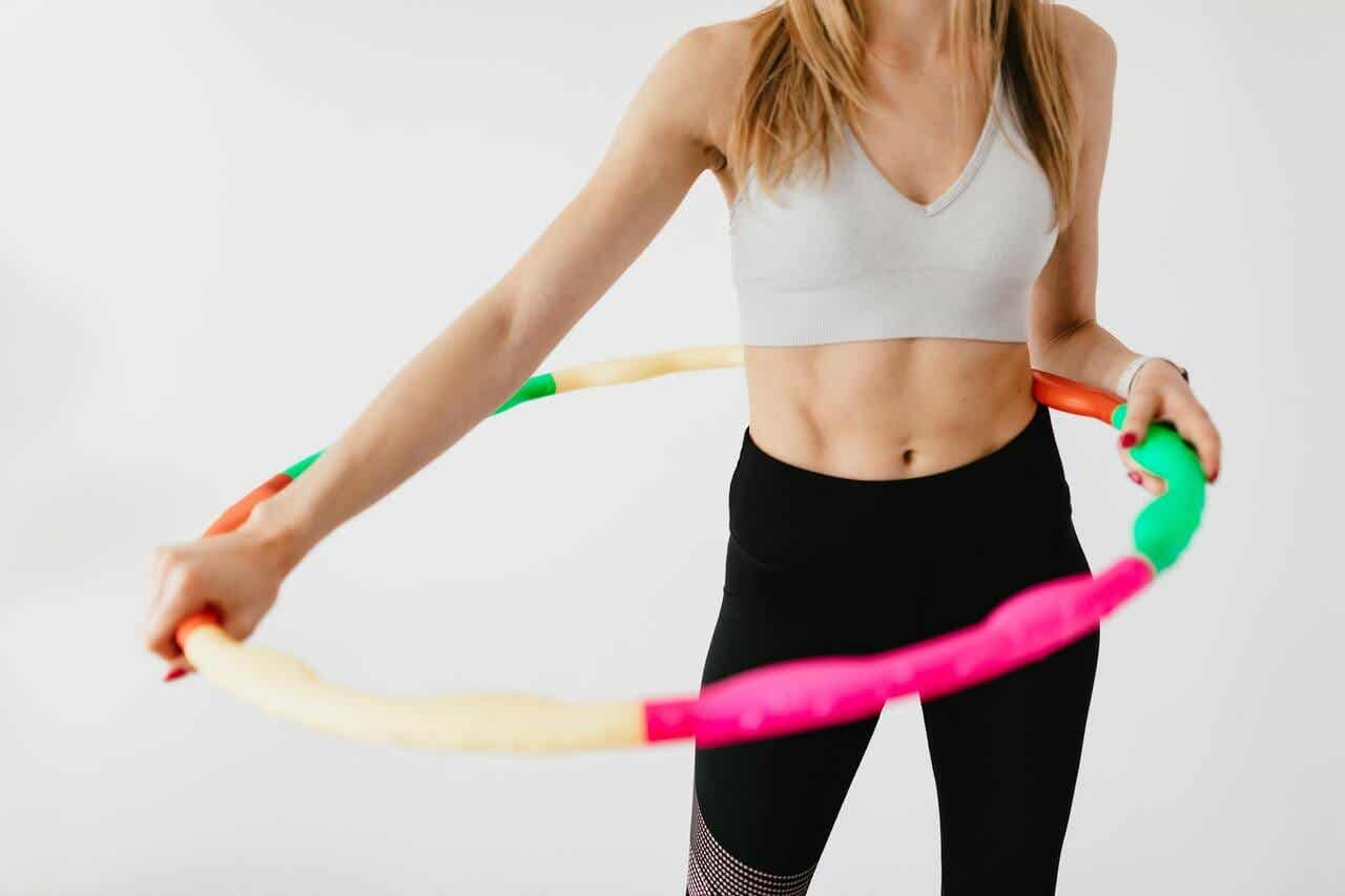 a woman using weighted hula hoops