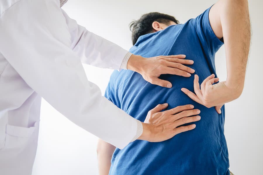 Fisioterapeuta examinando los los dolores del nervio ciático.
