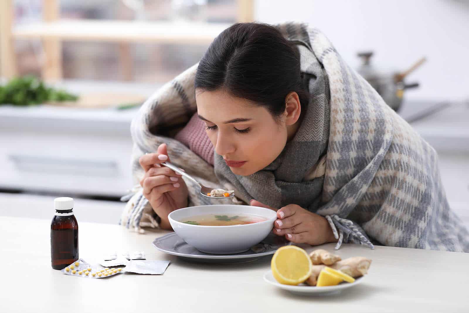 Femme avec la grippe mangeant de la soupe.