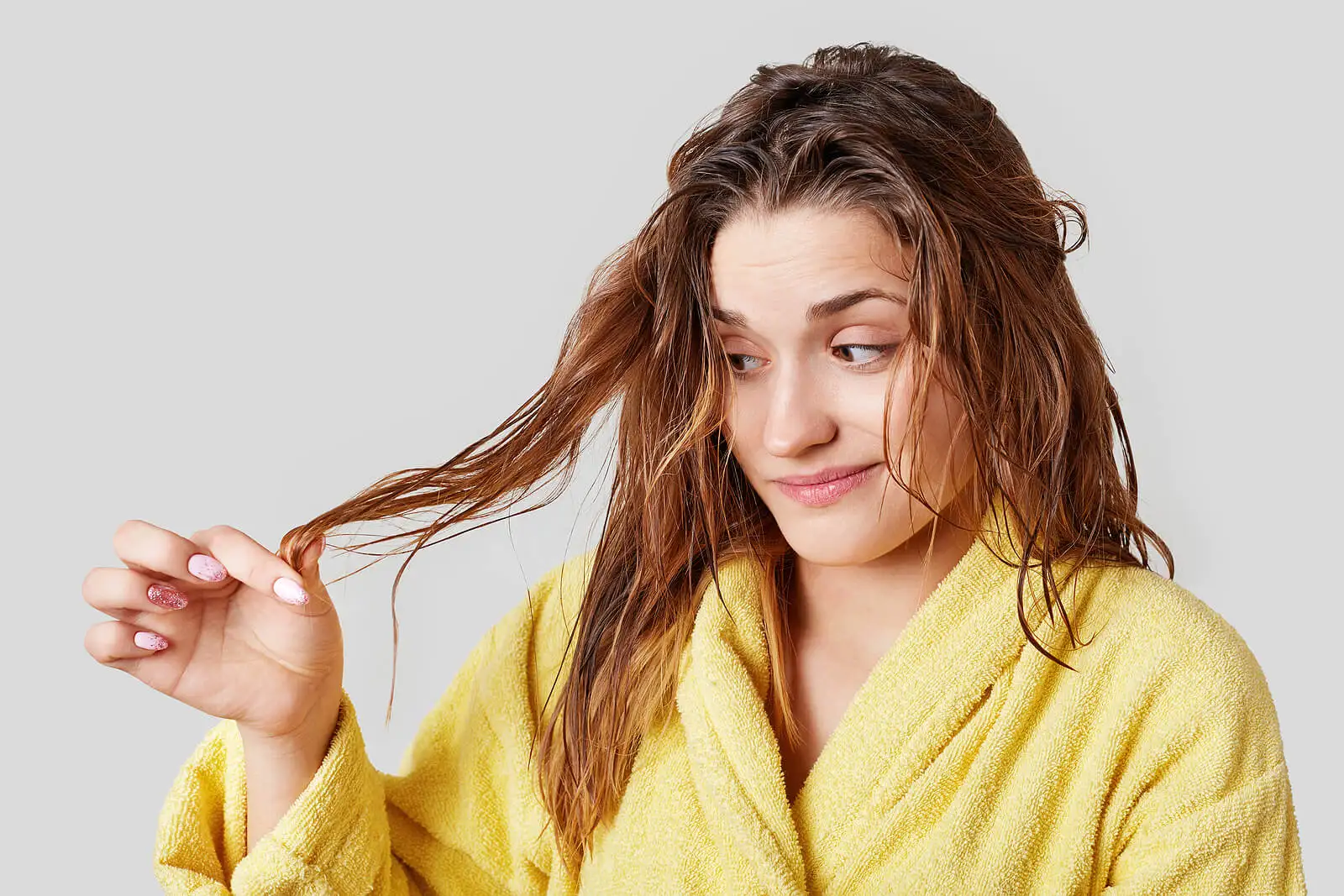 Pelo mojado dañado en una mujer que no usa secador de pelo iónico.