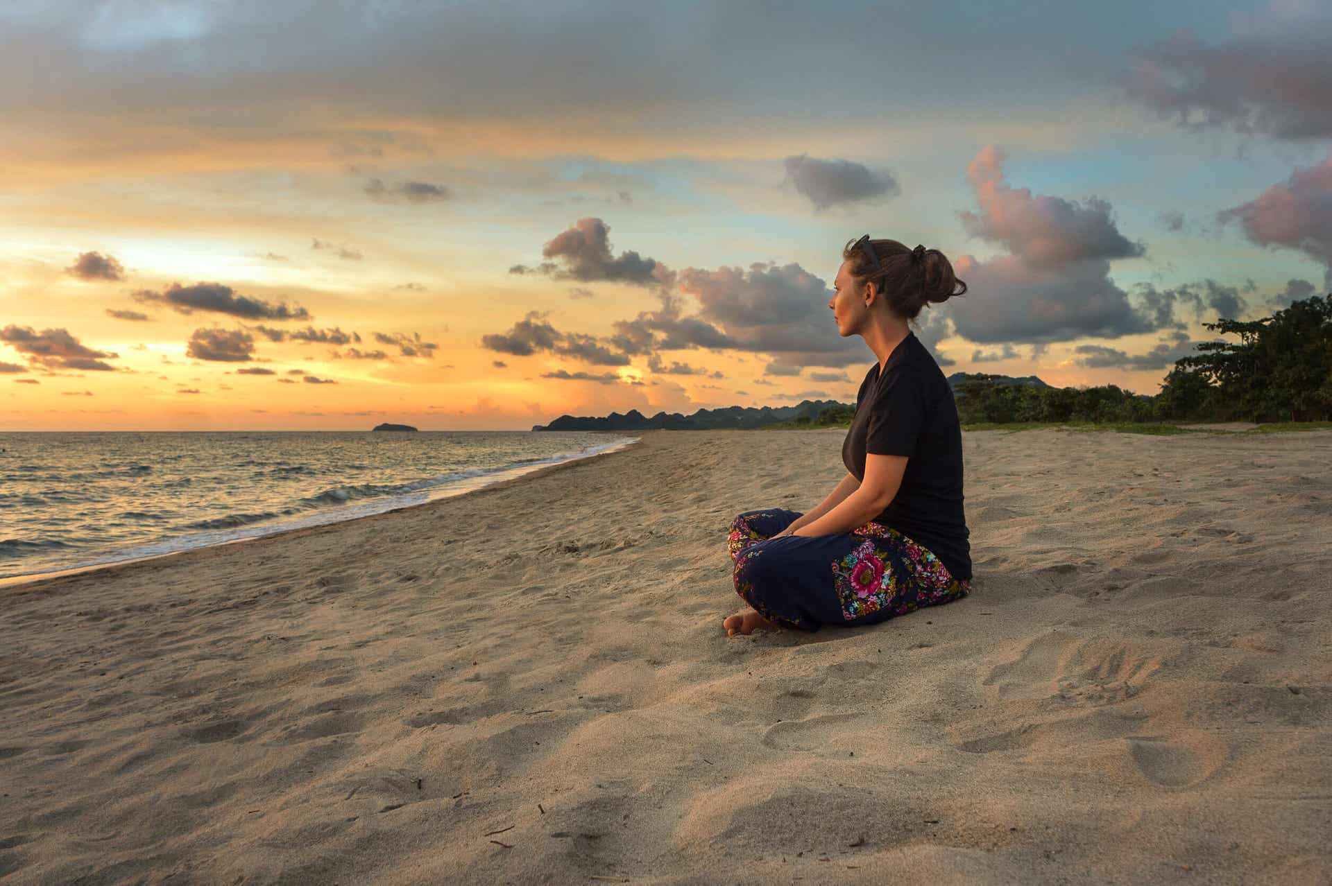 Zen-Philosophie - Frau meditiert am Strand