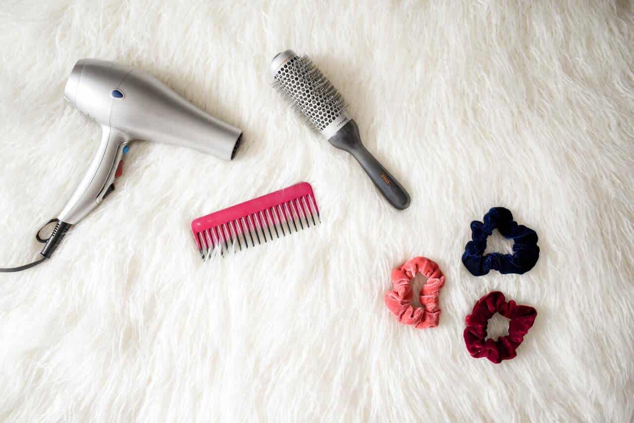 Secador de pelo, cepillo y coletas.