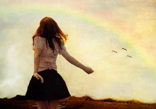 Mujer junto a arco iris, libre de quien la trata mal