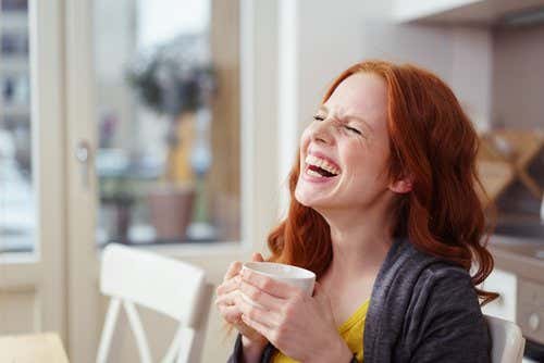 mujer con café riendo