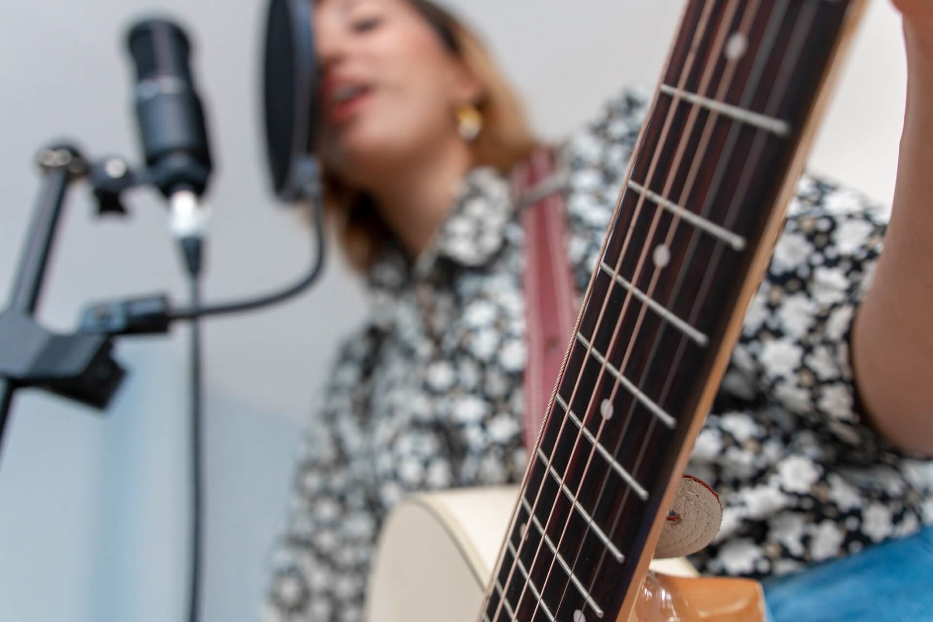 Mujer cantando y tocando guitarra