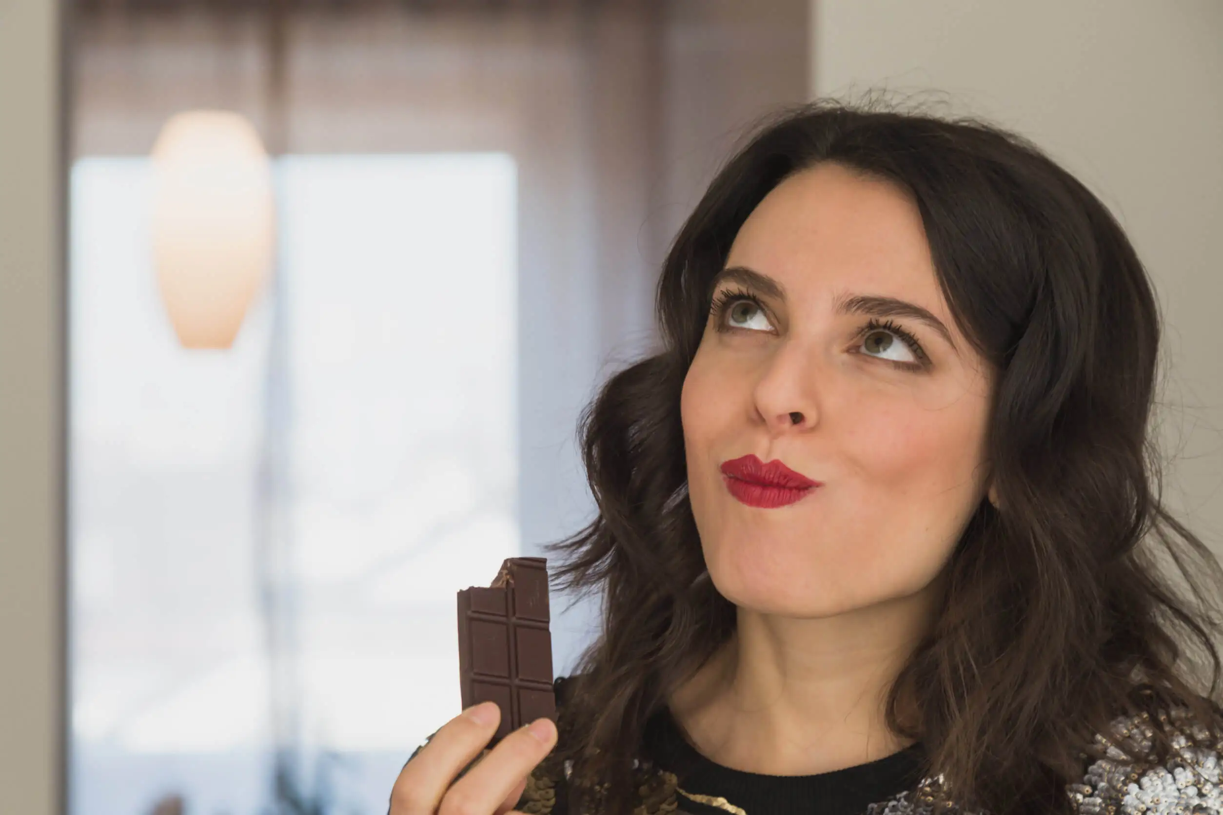 Blije vrouw eet chocolade