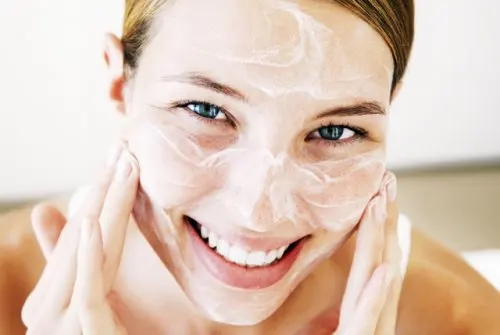 Smiling Young Woman Applying Face Cream