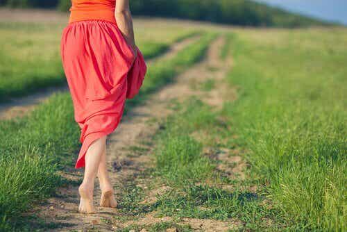 Mujer-con-falda-roja-andando-por-un-camino