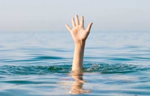 Hånd, der rækker op af vand, viser, at nogen er ved at drukne