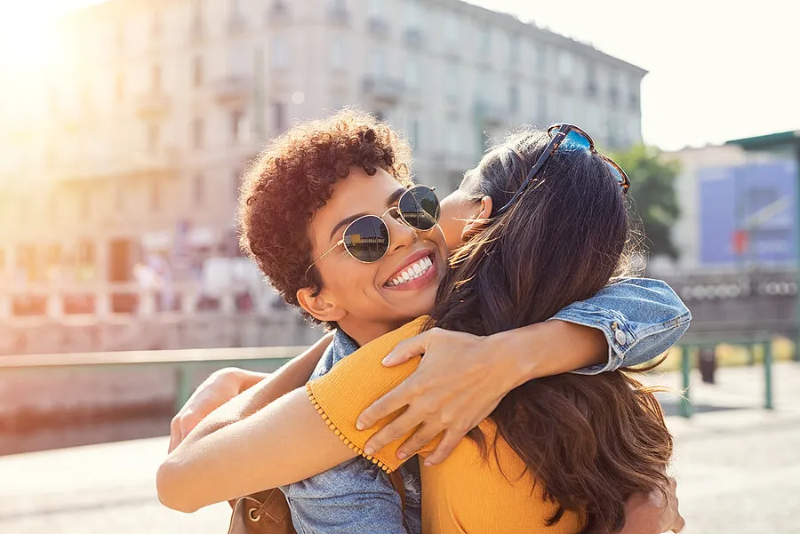 Una persona simpática sonríe y abraza a otros.
