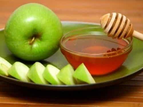Grønne epleskiver og en bolle med honning
