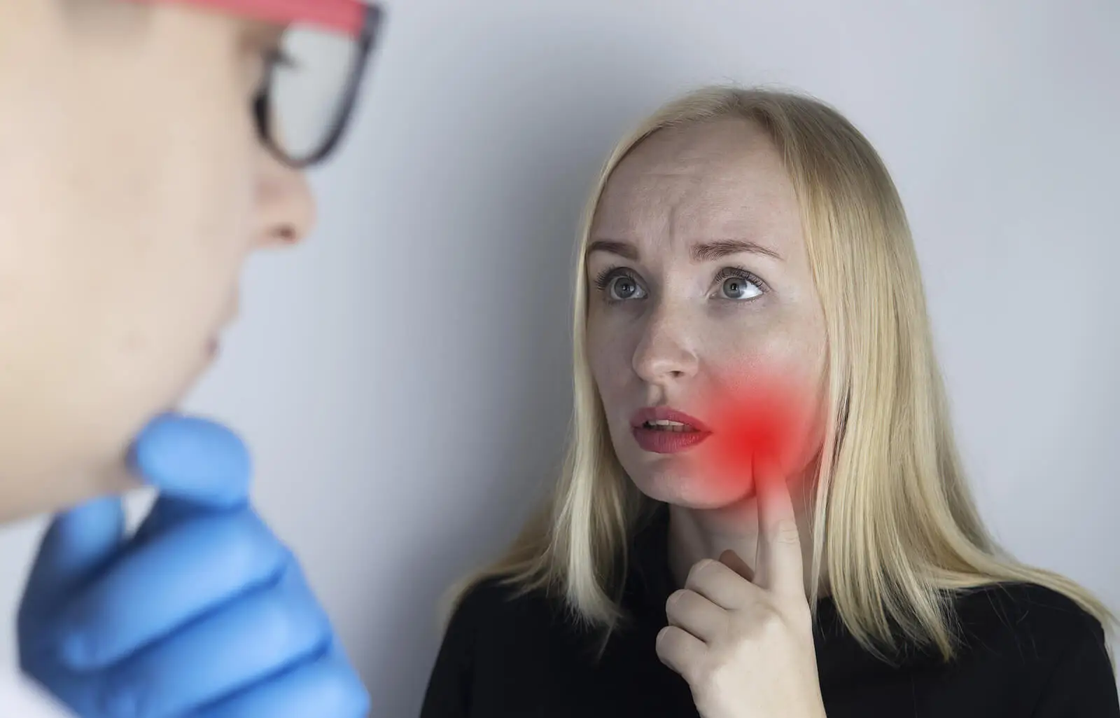 Médico y paciente averiguando causas del dolor mandibular.