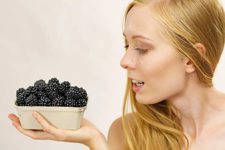 Frau mit einer Schale Brombeeren