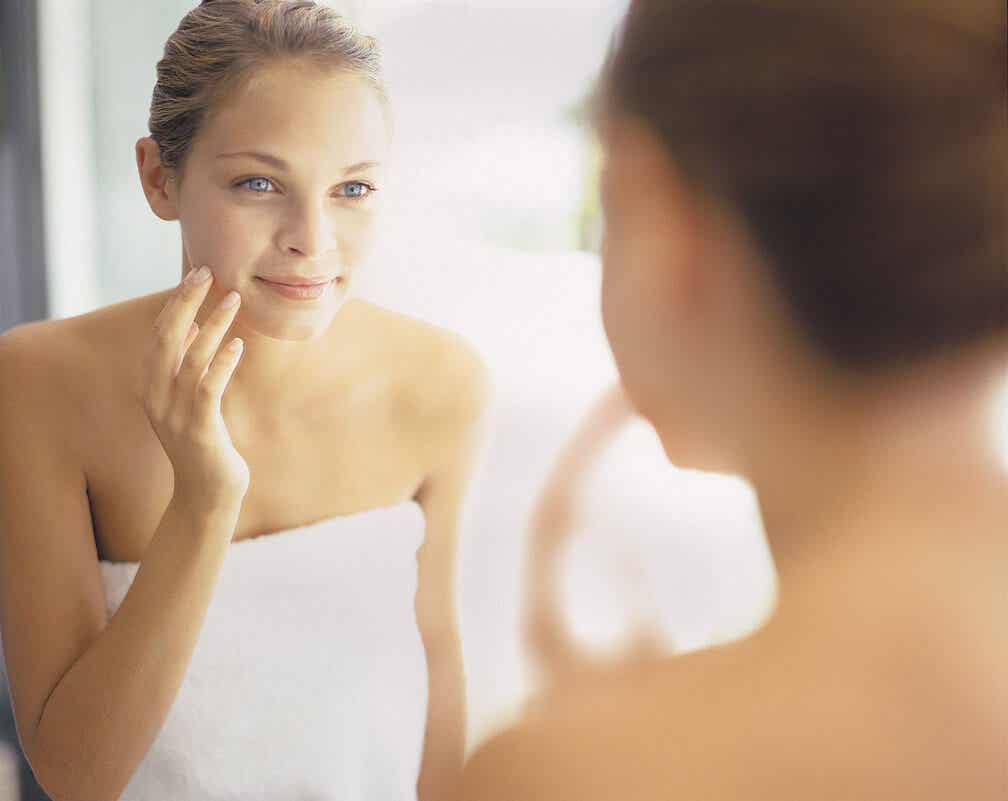 Mujer mirándose al espejo viéndose la piel.