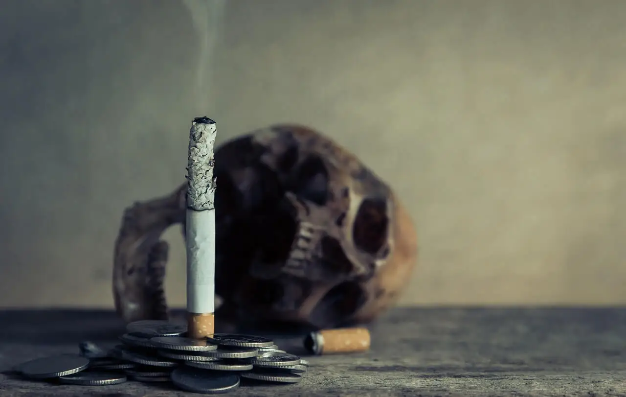 Cigarrillo, calavera y monedas.