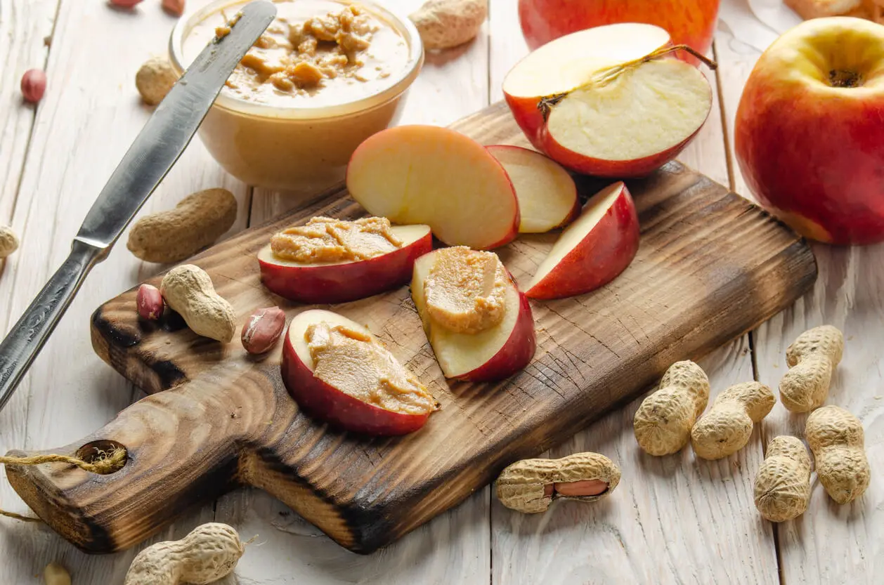 Manzana untada con mantequilla de cacahuete.
