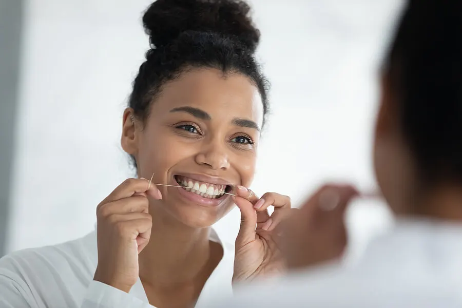 Mujer usando hilo dental