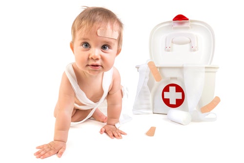 Bebé junto a un botiquín de primeros auxilios