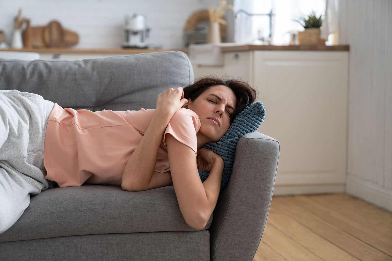 Mujer en el sofá con agotamiento extremo.