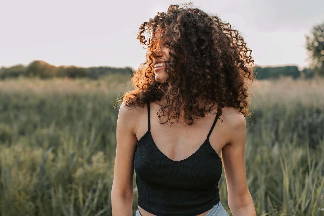 Mujer sonriendo en una pradera en verano.