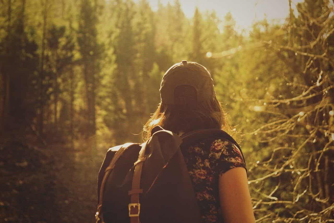 Mujer con mochila en el bosque.