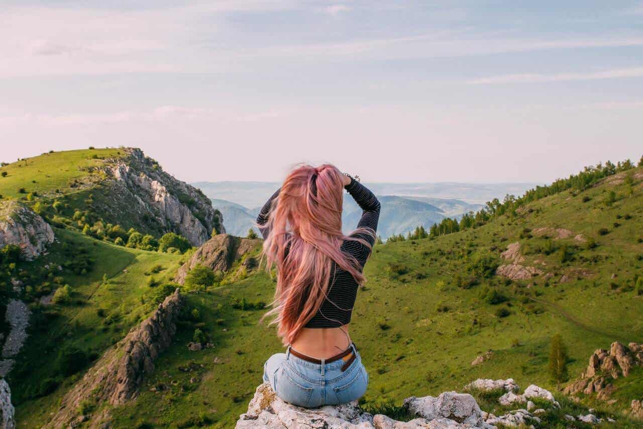 Mujer en las montañas mirando el paisaje.