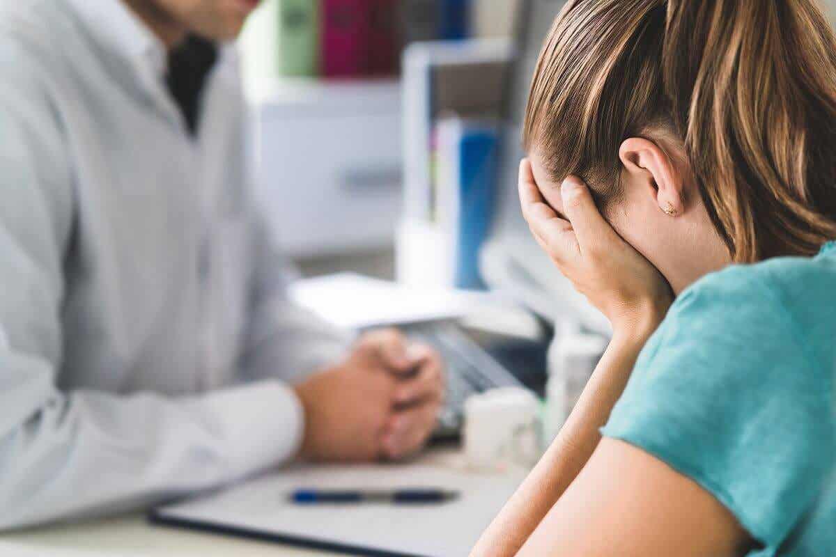 Paciente llorando en consulta con su médico.