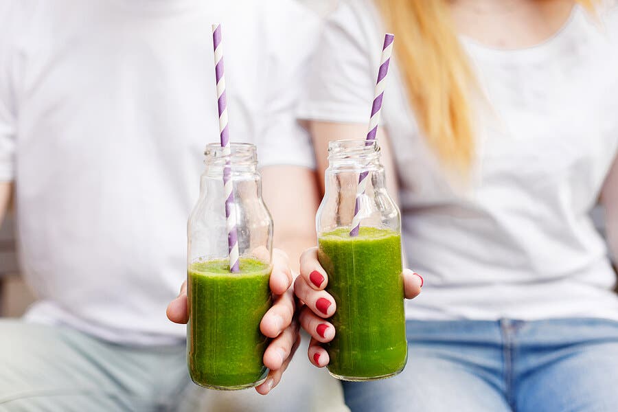 Personas con botellas de batidos verdes.