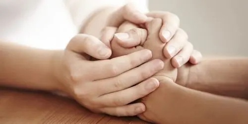 Manos abrazando las manos de otra persona