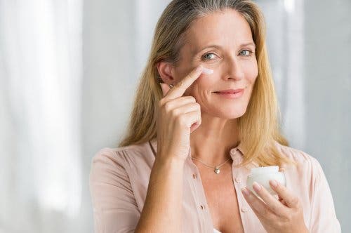 Mujer aplicándose crema sobre el rostro