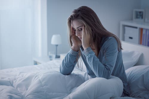 mujer despiesta en la cama con insomnio