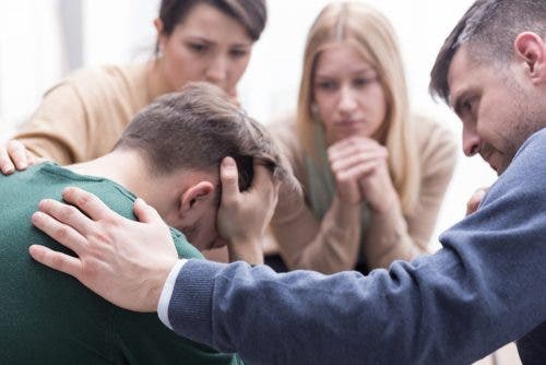 Chico llorando rodeado de amigos