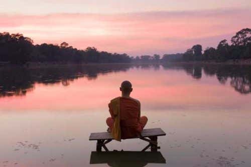 monje-meditando-delante-de-lago