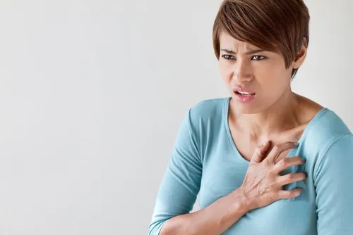 Mujer con la mano en el pecho.
