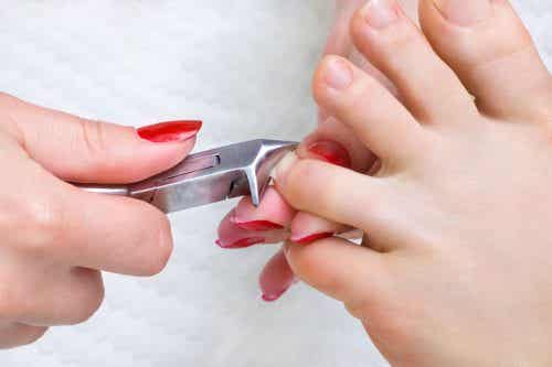Madre cortando las uñas de los pies a su hijo