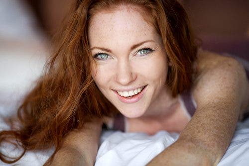 mujer pelirroja con pecas