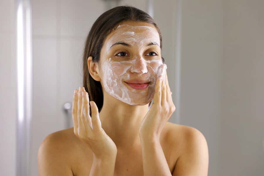 Mujer lavándose la cara para eliminar el acné.
