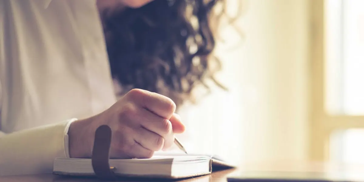 Mujer escribiendo en su diario personal.