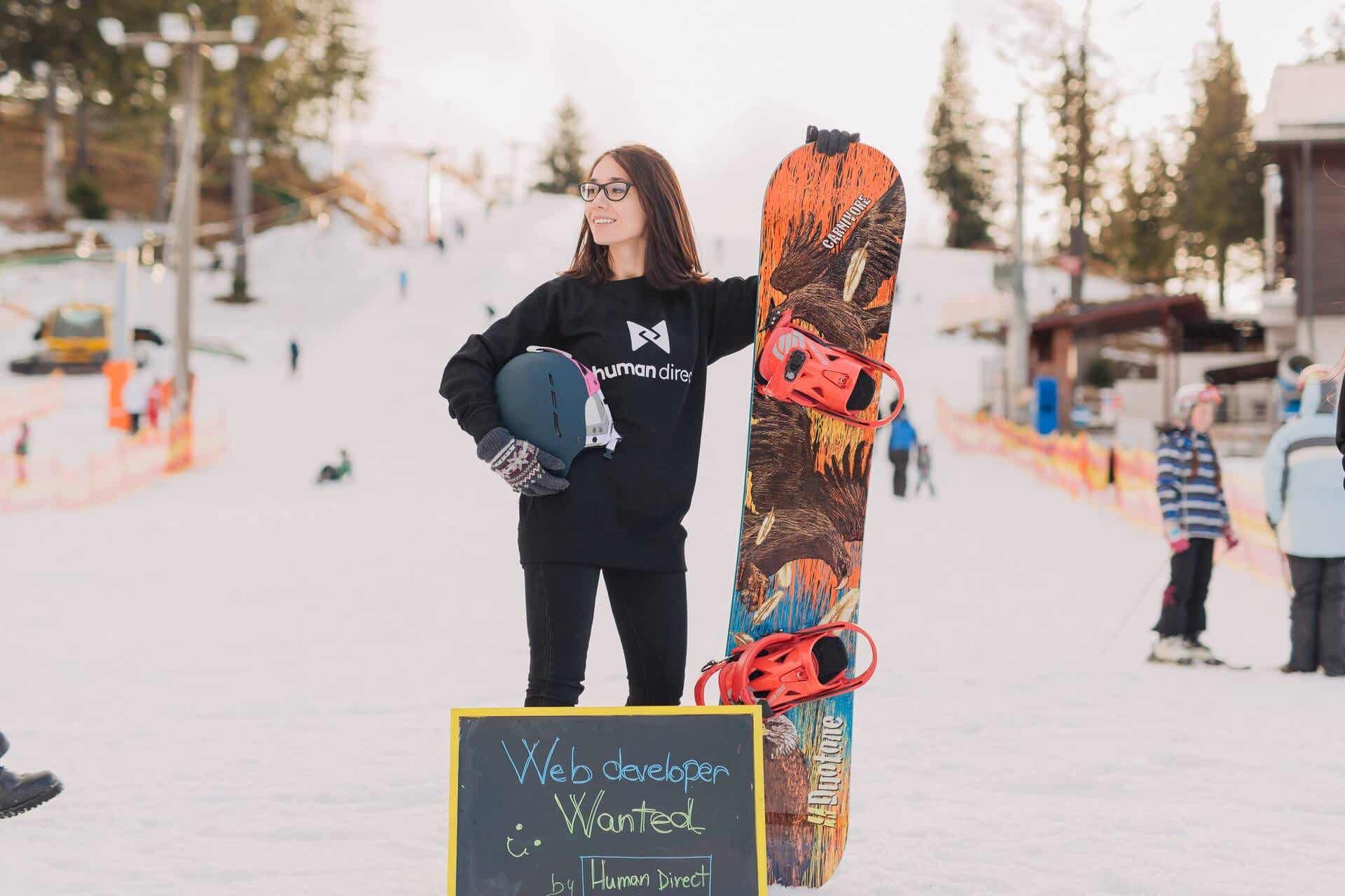 Mujer usando gafas y una tabla de snowboard.