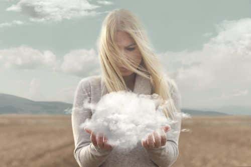 Mujer mirando nube entre sus manos y que piensa en no estresarse