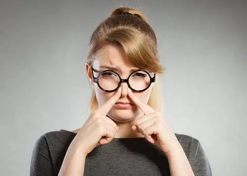 Mujer tapándose la nariz