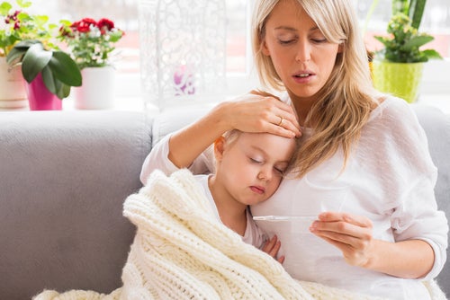 Madre midiendo la fiebre de su hija