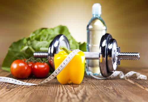 Alimentos saludables, una pesa y una cinta métrica