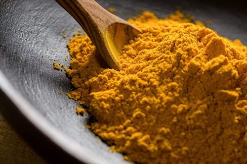 Close up of a bowl of ground turmeric.