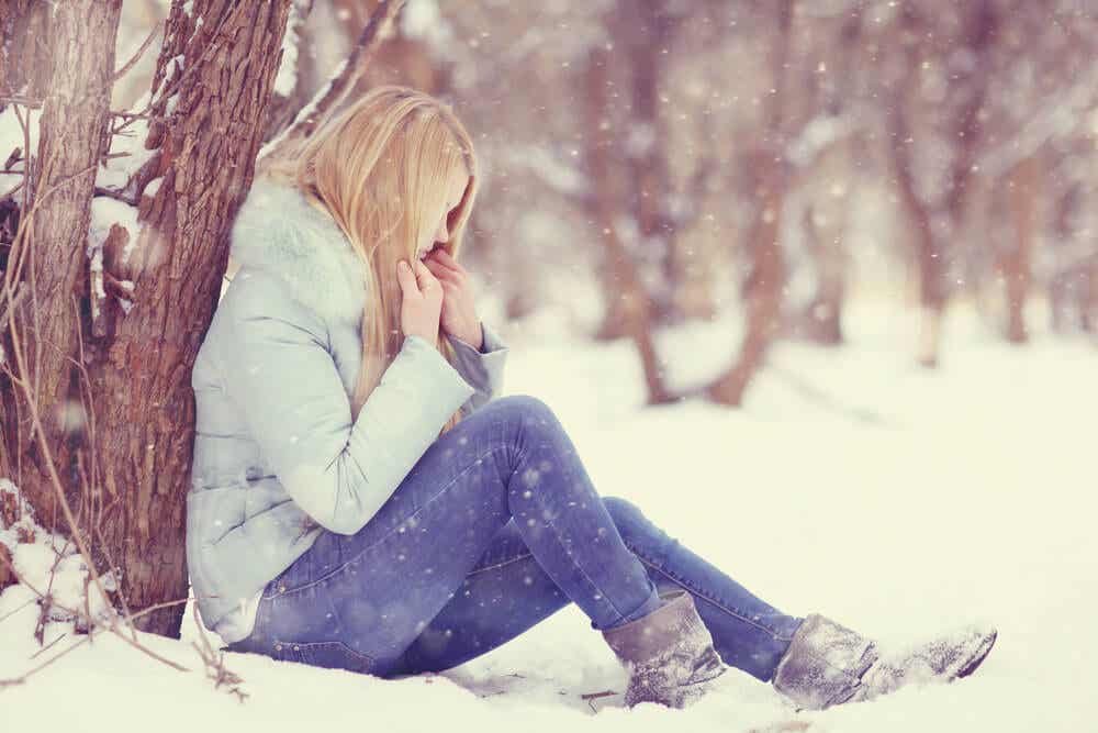 Mujer en la nieve con síntomas de hipotermia