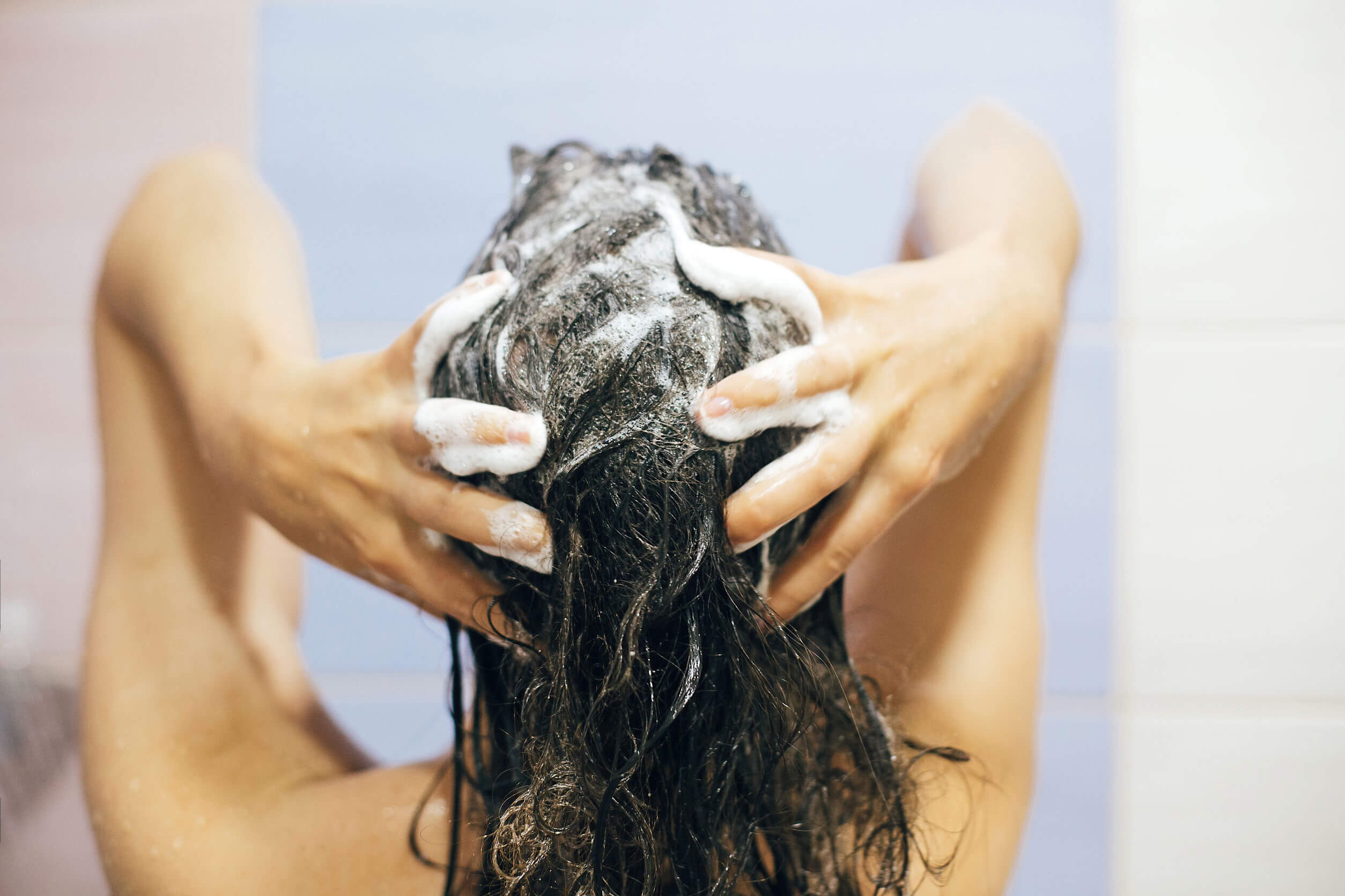 En kvinne som vasker håret.