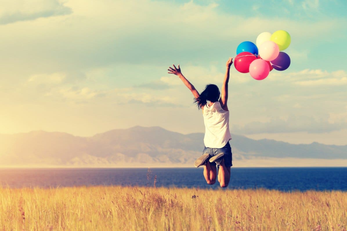 Mujer saltando con globos