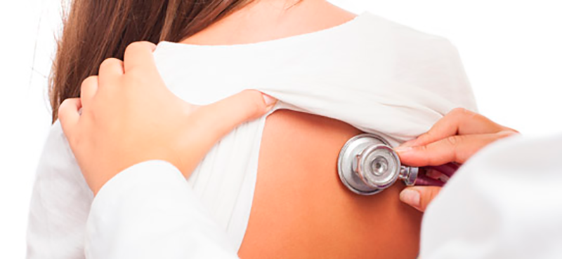 Médico auscultando a una mujer