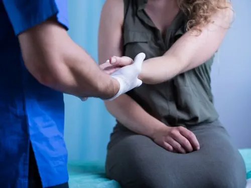 Médico observando la mano de una chica